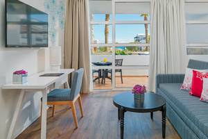 Innenraum des H10 Rubicon Palace mit Arbeitsbereich, Couch und Tisch.