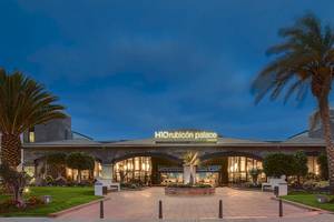 Außenansicht des H10 Rubicon Palace Hotels bei Nacht mit Beleuchtung und Palmen