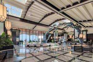 Die Lobby des H10 Rubicon Palace Hotels mit schwarzen und weißen Fliesen und einer hohen Decke mit Delphinen.