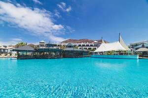 Das H10 Rubicon Palace Hotel mit einer blauen Poollandschaft im Hintergrund.