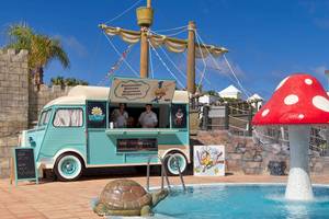 Eiswagen von H10 Rubicon Palace neben einem Pool mit einer riesigen roten Pilzskulptur.