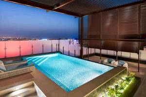 Ein Swimmingpool auf der Dachterrasse des Grand Millennium Muscat Hotels bei Nacht