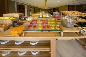 Frühstücksbuffet im Grand Millennium Muscat mit Obst, Getränken und Gebäck.