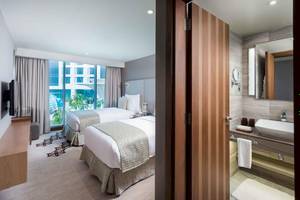 Doppelbettzimmer im Grand Millennium Muscat Hotel mit Blick auf die Stadt.