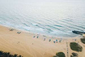 Oberflächenansicht eines Strandes mit mehreren Booten und Personen.