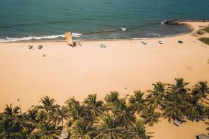 Luftaufnahme des Goldi Sands Hotels, Strand mit Palmen und kleinen Booten.