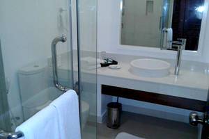 Goldi Sands Hotel Badezimmer mit Glasdusche, Waschbecken und Toilette.