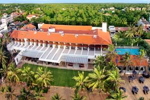 Luftaufnahme des Goldi Sands Hotels am Strand mit Swimmingpool und Palmen.