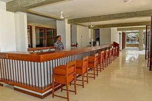 Ein Hotelbar mit Barkeeper und roten Stühlen, Goldi Sands Hotel