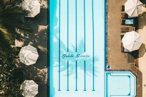 Oberflächenansicht des Goldi Sands Hotels mit Swimmingpool, Sonnenliegen und Sonnenschirmen.