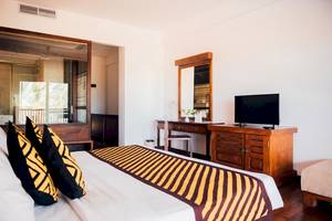 Hotelzimmer von Goldi Sands mit Bett, Fernseher und Schreibtisch