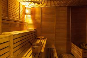Sauna im Adalya Bliss Hotel mit Holzbänken und einem Eimer auf der Bank