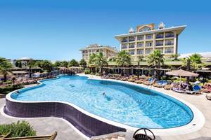 Außenpool des Adalya Bliss Hotels mit Sonnenliegen und Palmen
