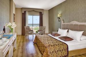 Innenansicht eines eleganten Hotelzimmers im Adalya Bliss Hotel mit Blick auf den Balkon.