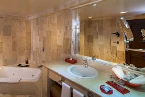 Ein Badezimmer mit Badewanne und Spiegel im Occidental Caribe Hotel