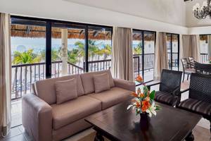 Wohnbereich des Allegro Playacar Hotels mit Blick auf das Meer und Palmen.