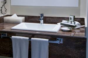 Badezimmer im Hotel Allegro Playacar mit Waschbecken, Handtüchern und Toilettenartikeln.
