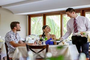 Ein Kellner serviert ein Paar im Allegro Playacar Hotel Restaurant.