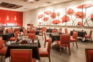 Innenansicht des Restaurants im Allegro Playacar Hotel mit roten Wänden und Tischdekoration.