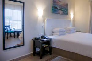 Hotelzimmer im Allegro Playacar mit einem Bett, Spiegel und Nachttisch.