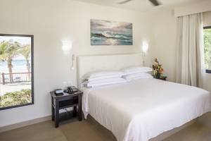 Schlafzimmer im Allegro Playacar Hotel mit Blick auf den Ozean und Möbeln.