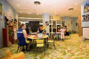 Kinderbetreuung im Hotel Maspalomas Princess mit einer Frau und Kindern an einem Tisch.