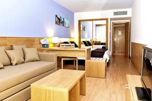 Hotelzimmer des Maspalomas Princess mit Sofa, Schreibtisch und Fernseher.