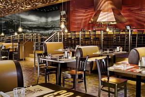 Innenraum des Mirage Hotel & Casino mit rustikalem Dekor, Tischen und Stühlen.