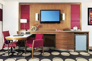 Arbeitsbereich im Mirage Hotel & Casino Zimmer mit Schreibtisch, Stühlen und Fernseher.