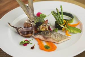 Fischgericht auf einem weißen Teller im Drift Thelu Veliga Retreat.