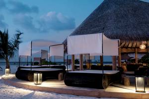 Außenbereich des Drift Thelu Veliga Retreat mit Strandbetten und Überdachungen