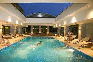 Einige Gäste entspannen und schwimmen im beheizten Innenpool des D'Andrea Mare Beach Hotels.