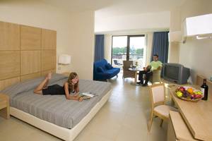 Junge Frau liegt auf einem Bett im D'Andrea Mare Beach Hotel Zimmer