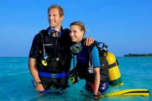 Ein Paar taucht im Meer vor dem Hurawalhi Island Resort