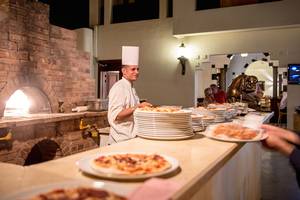 Koch im Sharm Plaza Hotel bereitet Pizzen zu und serviert sie auf einem großen Tresen.