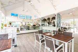 Innenansicht des Cafés im Katathani Phuket Beach Resort mit Tischen, Stühlen und Dekor.