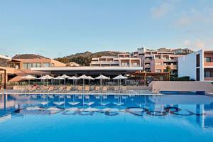 Außenbereich des Atlantica Mikri Poli Kos Hotels mit Swimmingpool und Sonnenliegen.