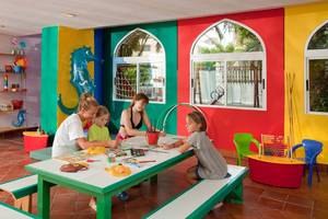 Ein buntes Kinderzimmer im Seaside Sandy Beach Hotel mit Erwachsenen und Kindern, die malen.