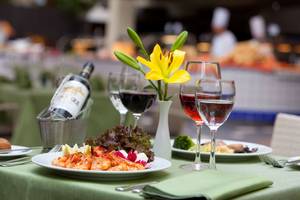 Speisetisch im Seaside Sandy Beach Hotel mit Garnelen, Wein und Salat.