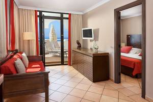 Suite-Zimmer im Seaside Sandy Beach Hotel mit Blick auf das Meer und einen Balkon.