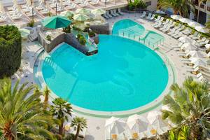Luftaufnahme des Pools im Seaside Sandy Beach Hotel mit vielen Liegen und Sonnenschirmen.