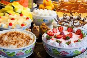 Mehrere Süßspeisen auf einem Buffet im Seaside Sandy Beach Hotel.
