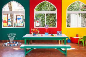 Kinderzimmer im Seaside Sandy Beach Hotel mit bunten Wänden, bunten Spielsachen und einem Tisch.