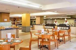 Innenansicht des Restaurants im Sol Tenerife Hotel mit gedeckten Tischen und Köchen hinter der Theke.