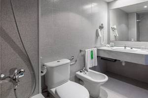 Ein Badezimmer im Sol Tenerife Hotel mit einer Dusche, Toilette, Bidet und Waschbecken.