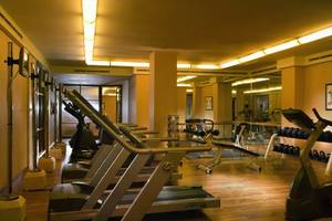 Fitnesscenter im Conrad Bali Resort & Spa mit Laufbändern, Hanteln und Spiegeln.