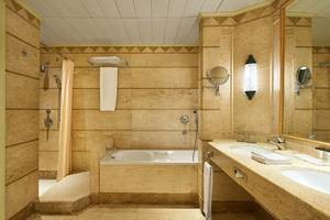 Badezimmer im Sheraton Soma Bay Resort mit Badewanne, Dusche, Waschbecken und Spiegel.