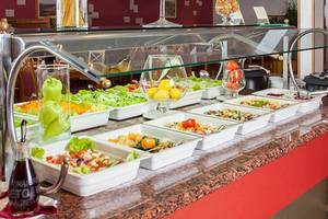 Buffet im Zora Hotel mit verschiedenen Salaten und Beilagen in weißen Schalen.