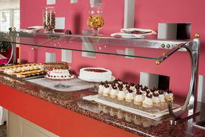 Buffet-Tisch im Zora Hotel mit verschiedenen Kuchen und Desserts.