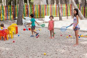 Kinder spielen auf einem bunten Spielplatz im Freien im Zora Hotel.